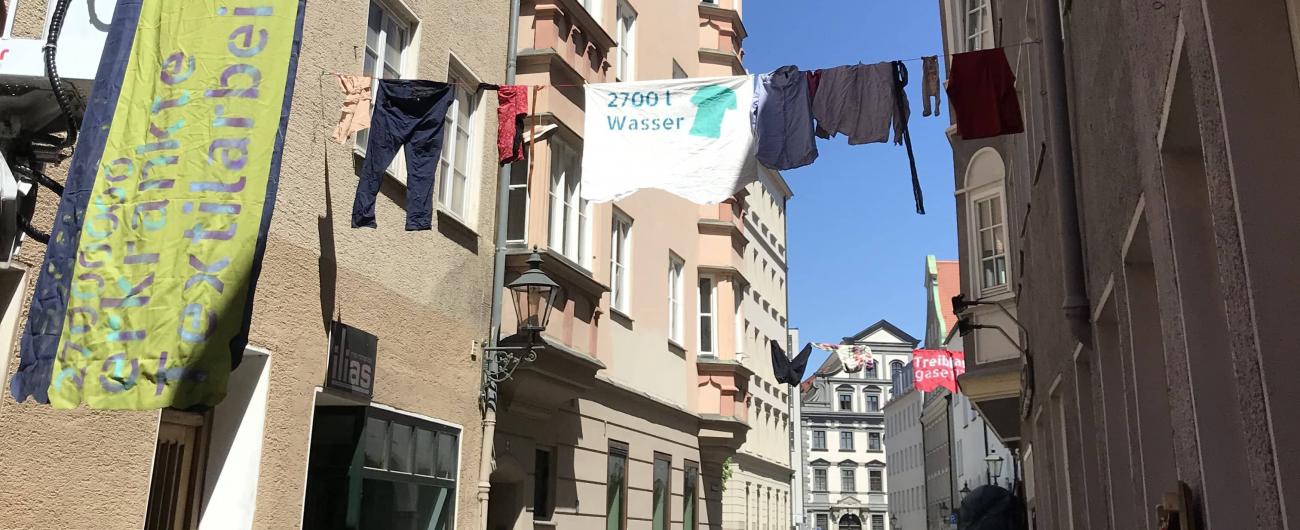 'Hängengelassen - die Altkleiderwelle' heißt diese Kunstinstallation, die anlässlich der KANU WM 2022 in der Augsburger Altstadt installiert wurde. Foto: Carolin Loser